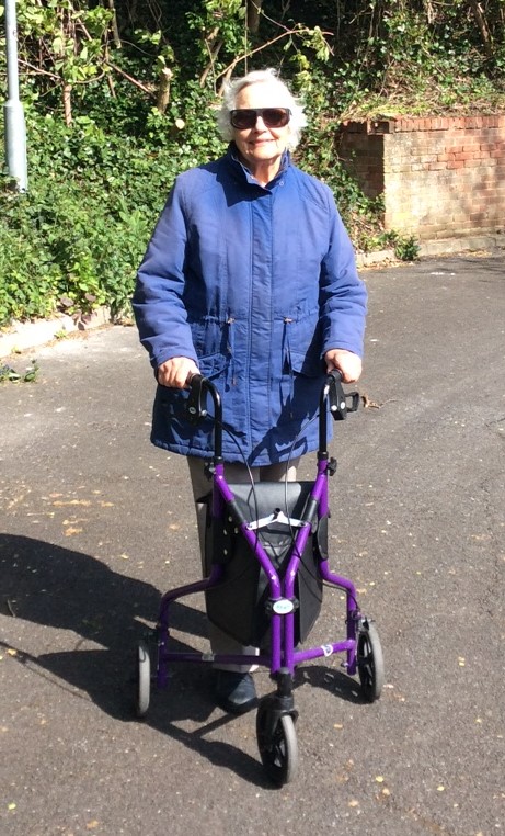 Margaret standing outside with her walker.