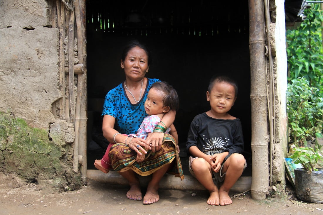 Sudip sat in the doorway of his home with his mother and baby sister