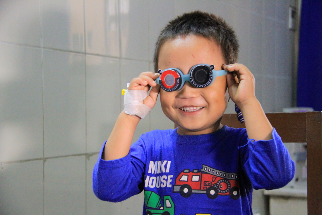 Sudip smiling and putting on eye examination glasses