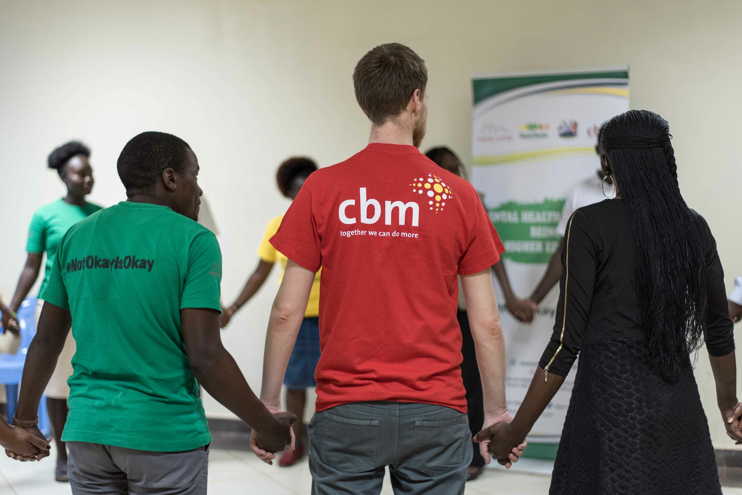 BasicNeeds and CBM staff holding hands.