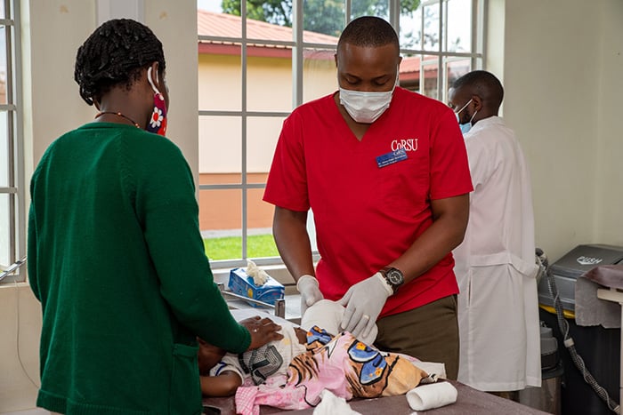 Dr Fisha attends to a baby with casts on their feet