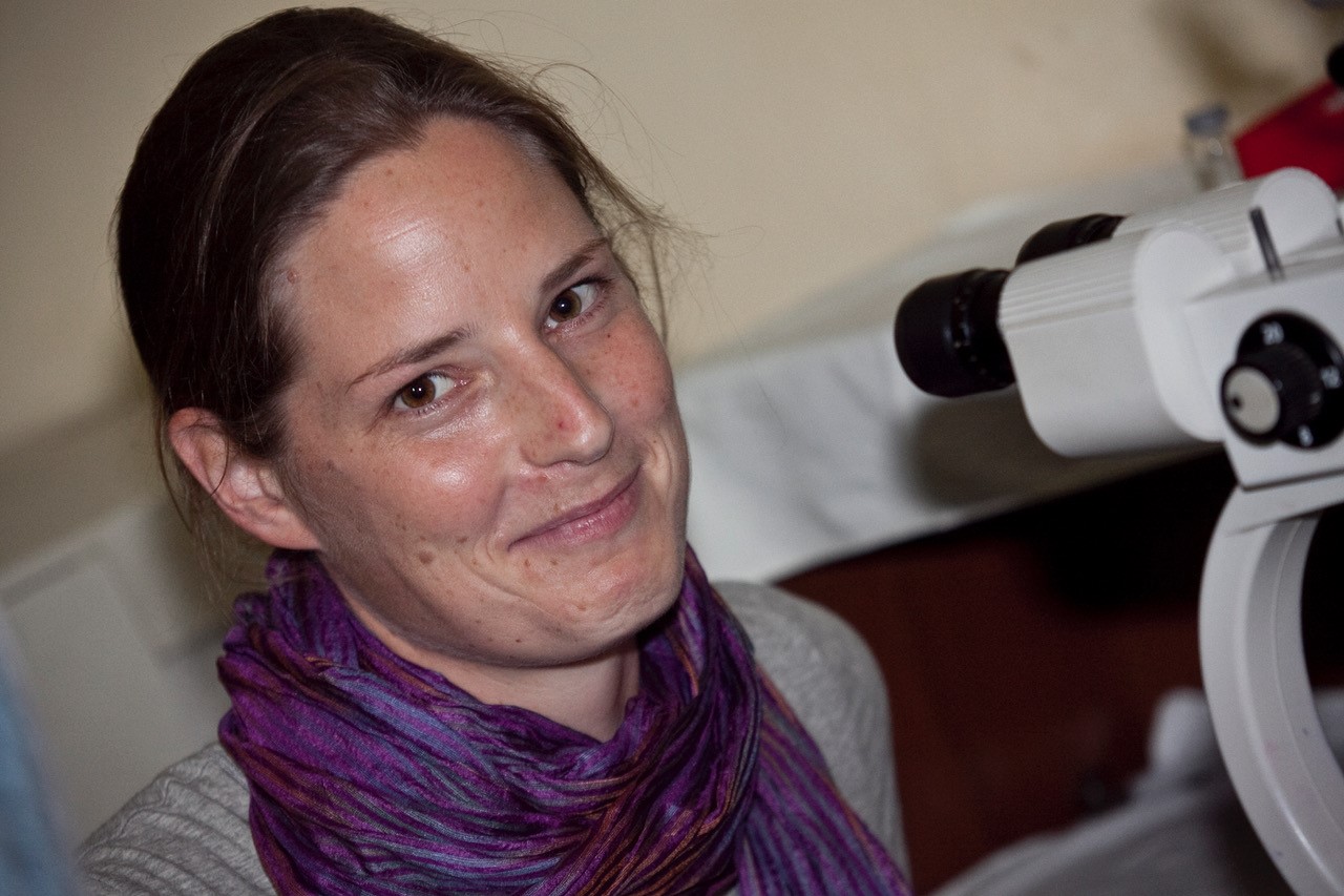Lady looking at the camera next to optometry equipment