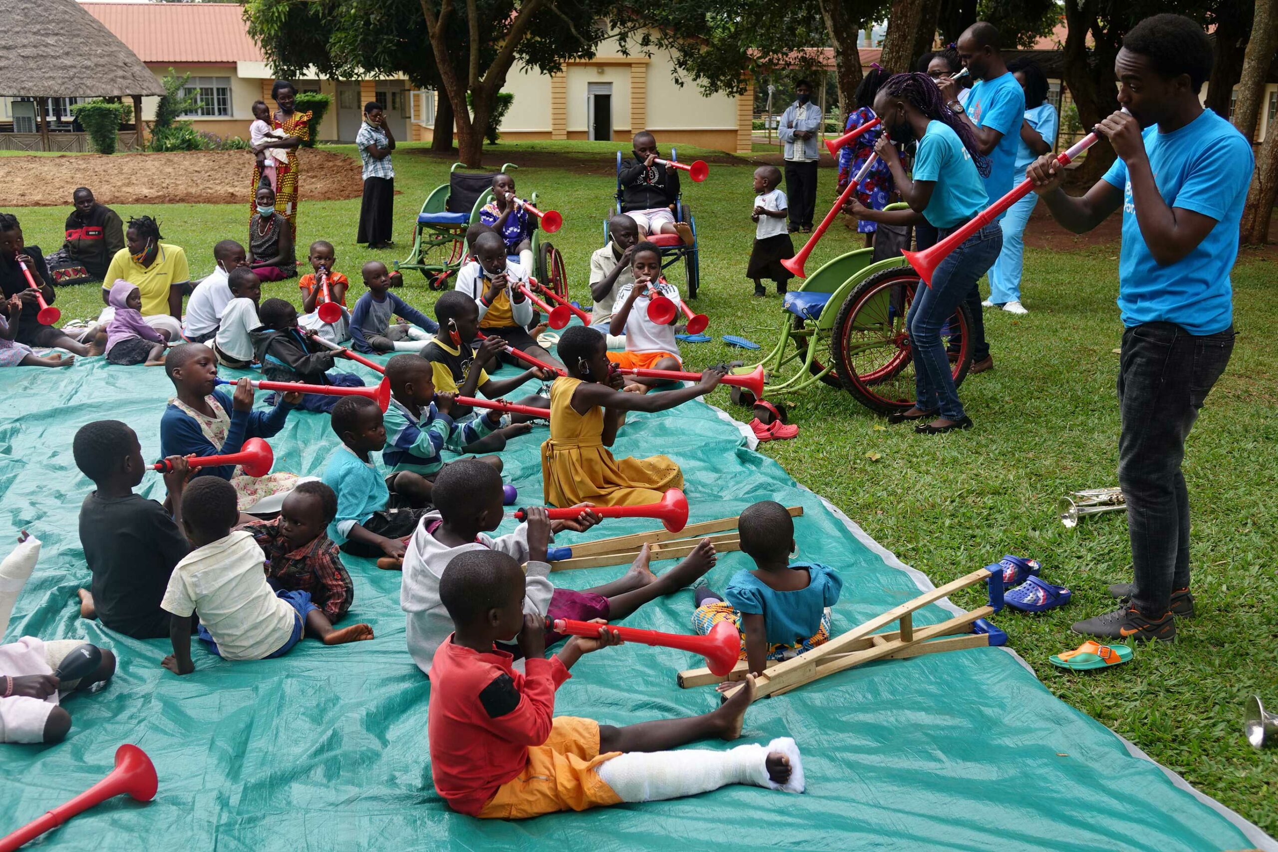 Children sat on the floor outside CoRSU, playing musical instruments.