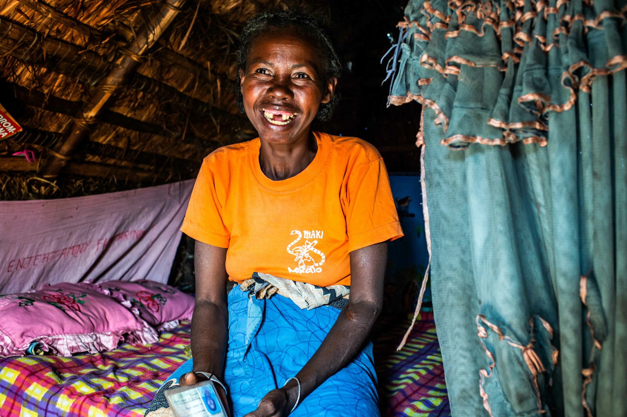 Haova sitting on her bed smiling.