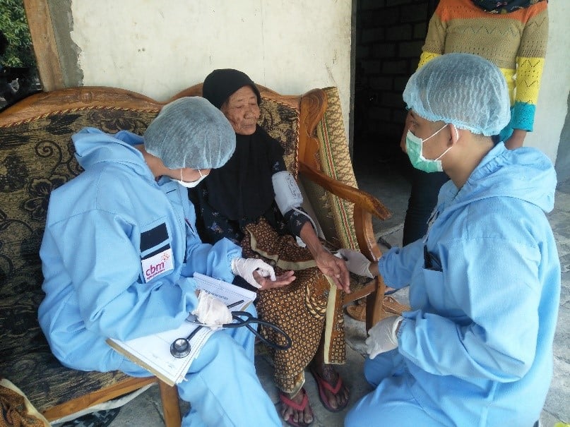 Health workers visiting an elderly lady at home during COVID-19