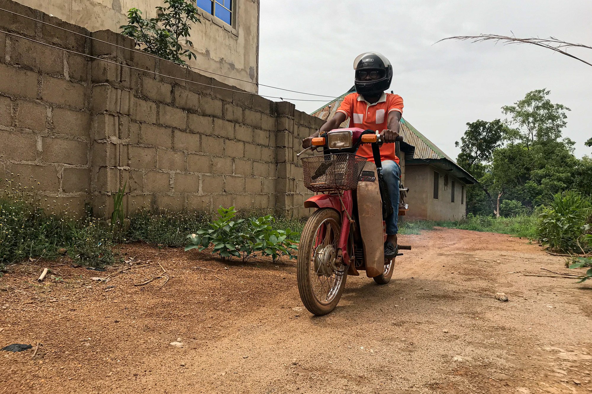 Samuel riding his motorbike, to visit patients at home.