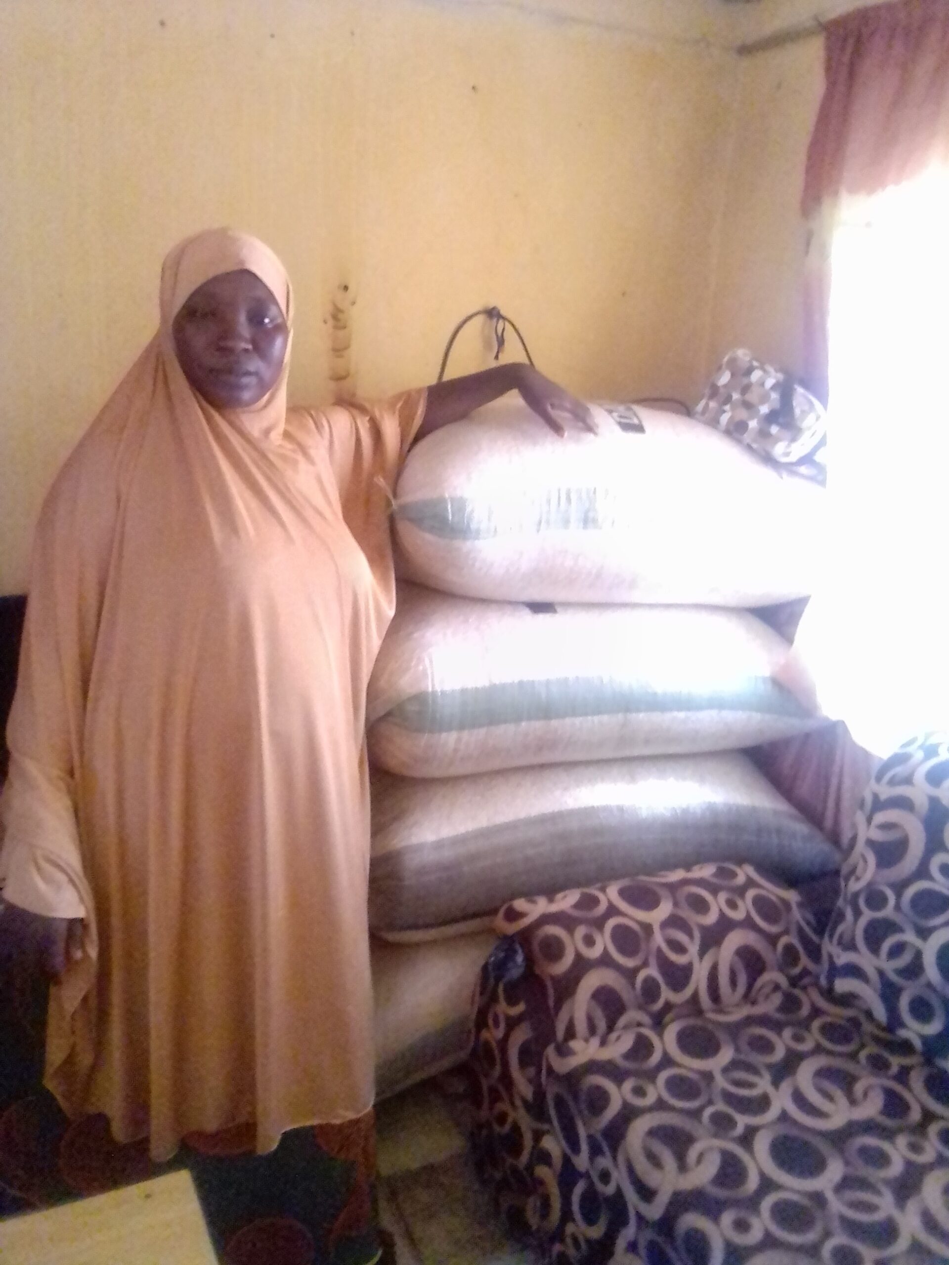 Khadijat stood at home, with her sacks of grain