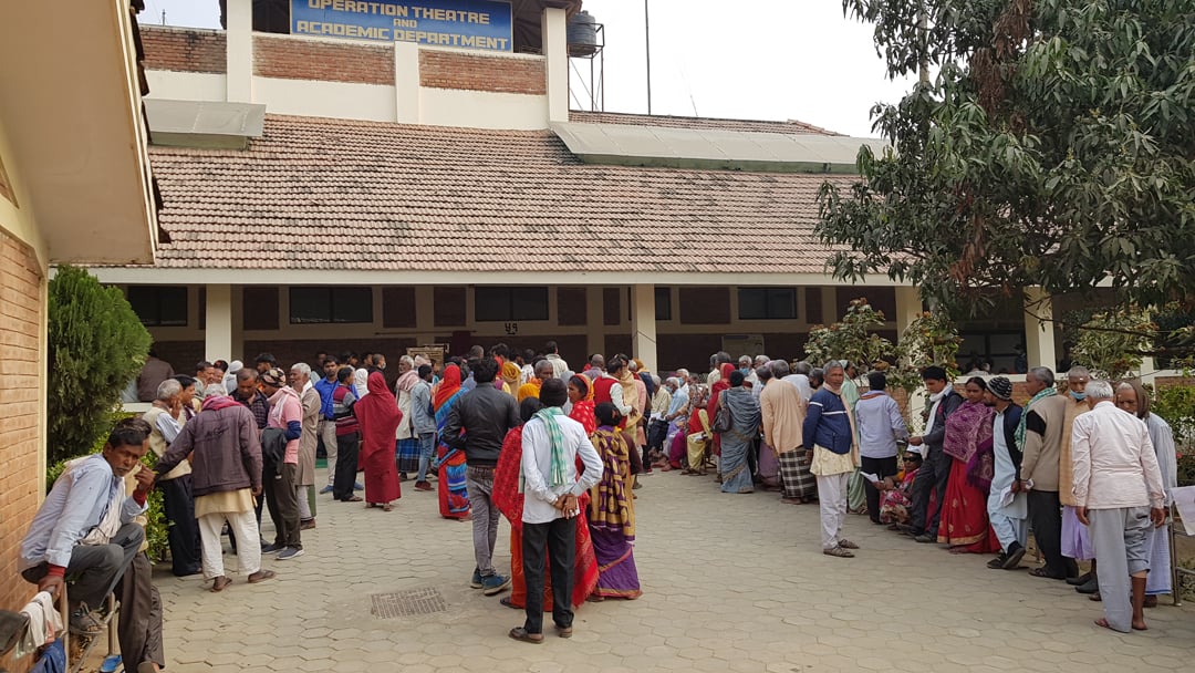 Queue of over thirty people outside hospital building