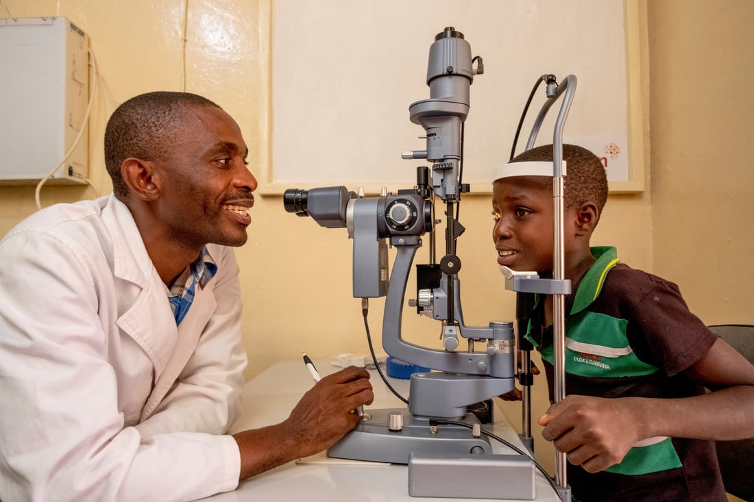 Dr Moyo and Jabes, smiling during an eye examination