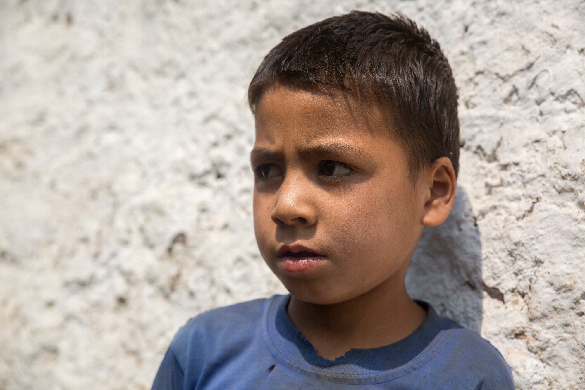 Yogendra is resting his head against a white wall. 