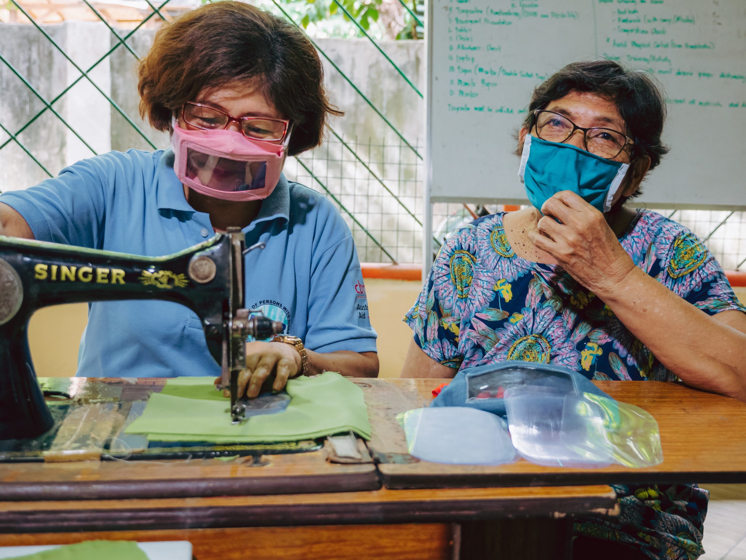Two women wearing inclusive face masks sewing in the Philippines