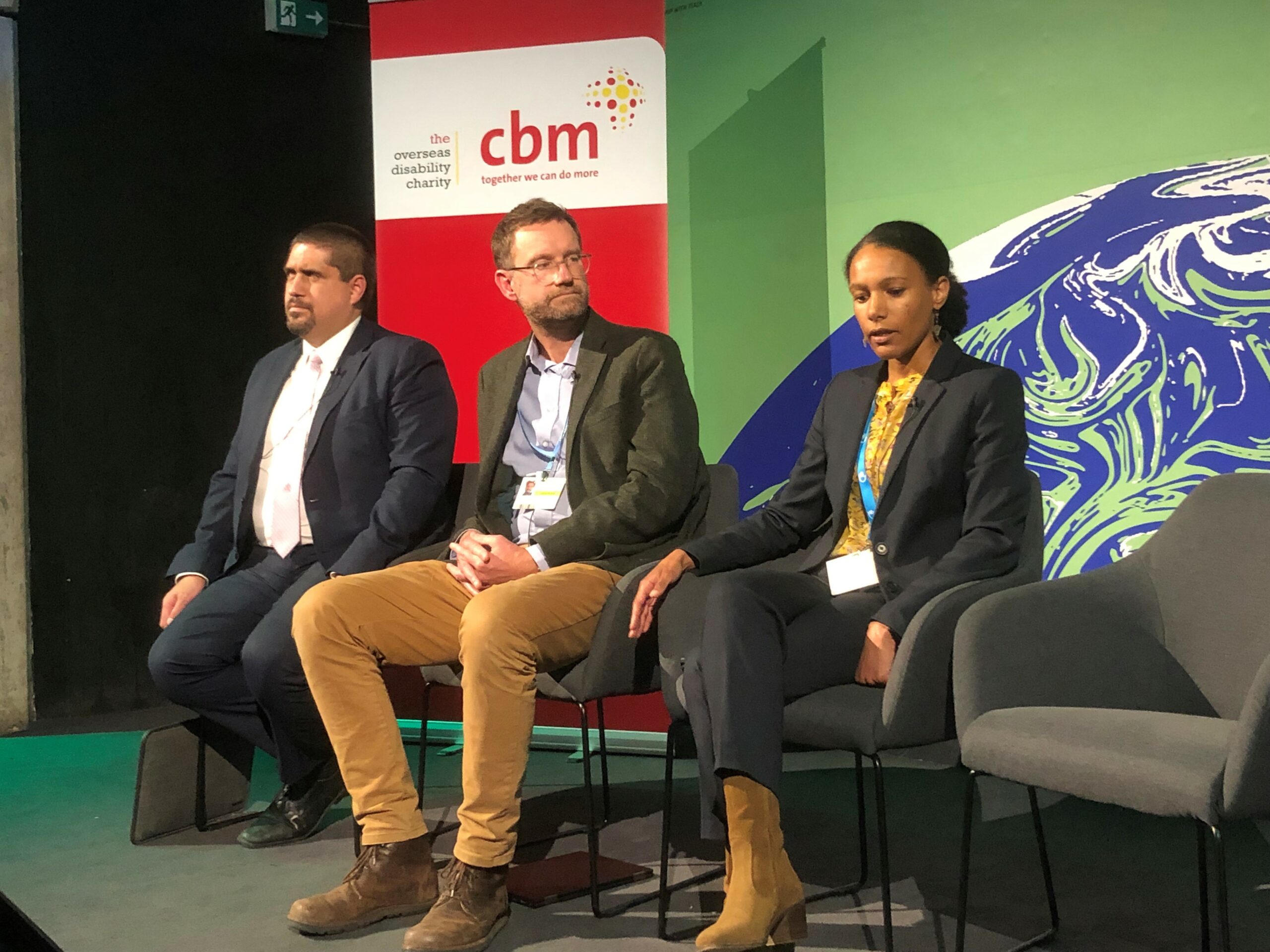 Three of the panel of experts speaking at CBM's COP26 event, sat on stage.