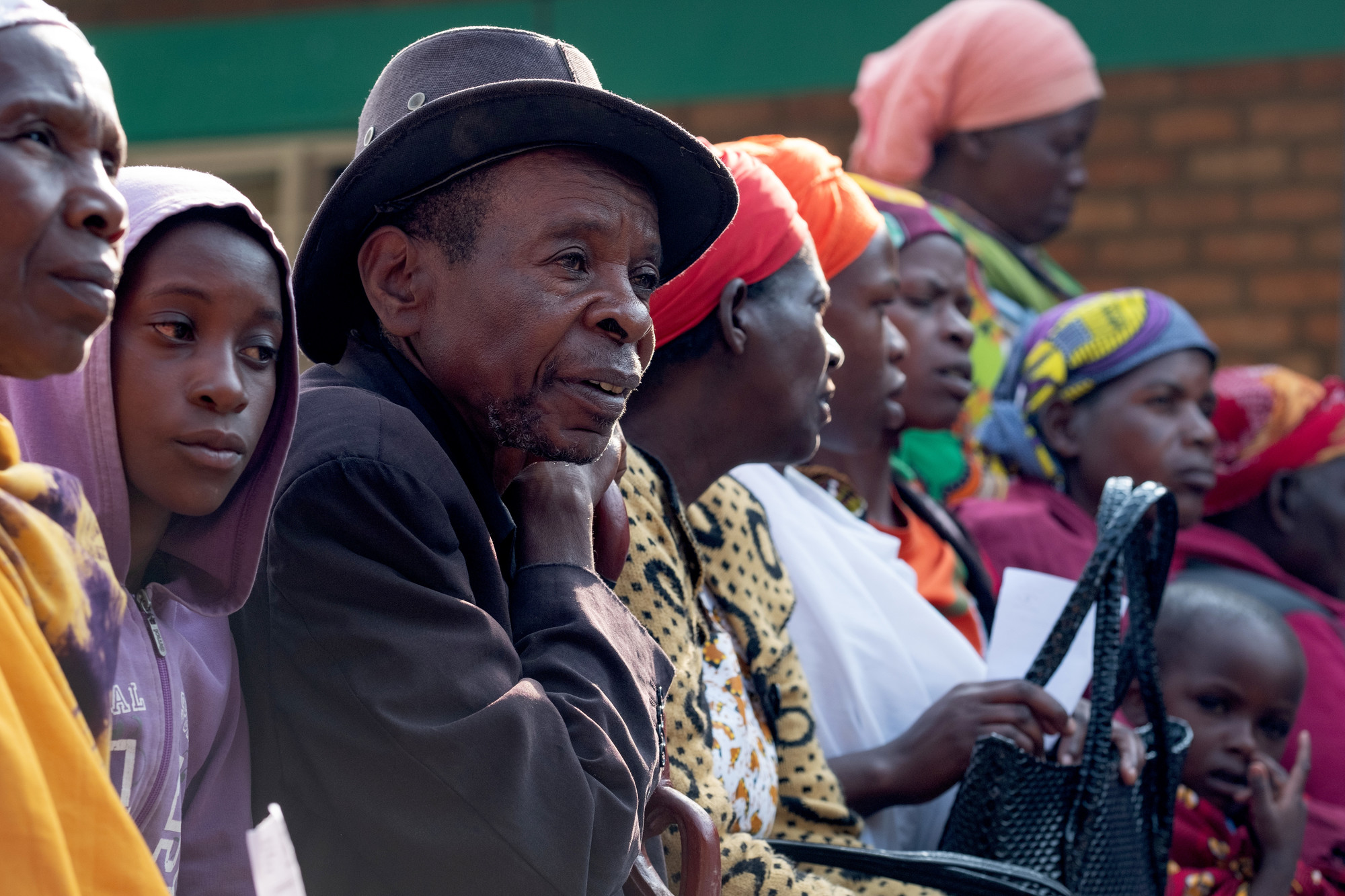 Charles from Rwanda sitting in a line of people.