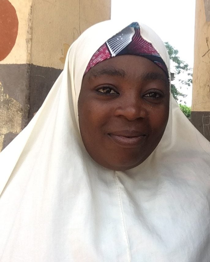 Headshot of Rukaya from Nigeria, smiling, wearing a head scarf.