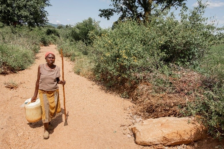 Sofia walking with a walking aid on a dusty surface, 