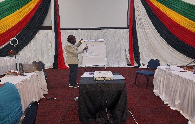 Man writing braille on a large piece of paper.