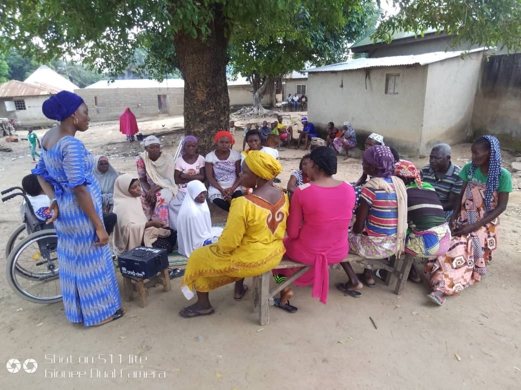Group of women sitting in a circle under a tree