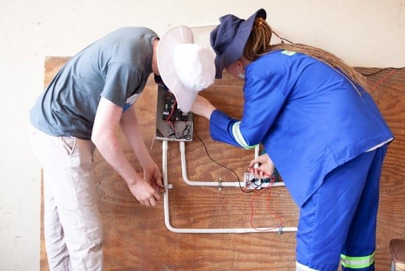 Youths doing electrical engineering showing off a circuit they made