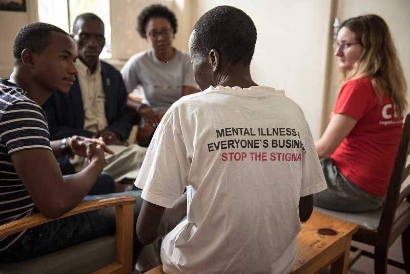 Mphatso attending a counselling session - MeHUCA committee member wear a t-shirt saying 'Mental illness. Everyone's business. Stop the stigma'. 