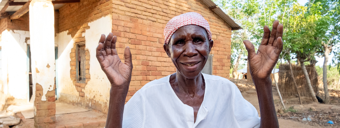 Dorothy, wearing white, smiles and waves to the camera.