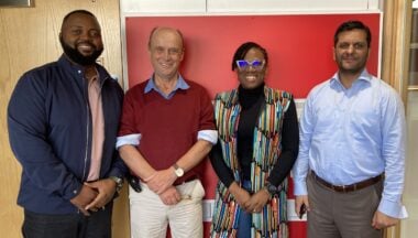 The four trustees stand in front of a red wall. From left to right, Fingani, Jim, Ifunfun and Amjad.