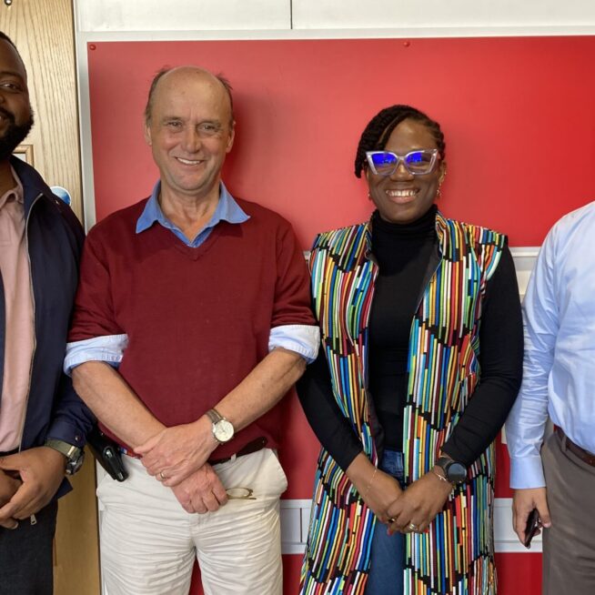 The four trustees stand in front of a red wall. From left to right, Fingani, Jim, Ifunfun and Amjad.