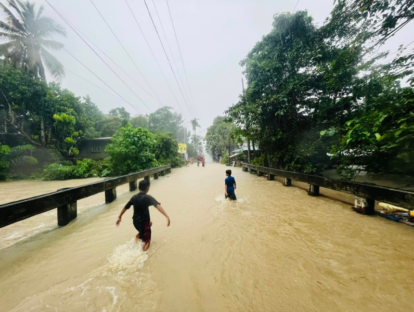 Two boys walk through flooding after typhoon Trami.