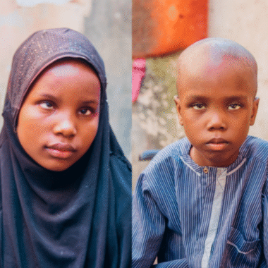 A young girl wearing a navy hijab and a young boy wearing a blue shirt.