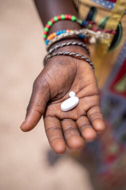 An open palm holding two white tablets.