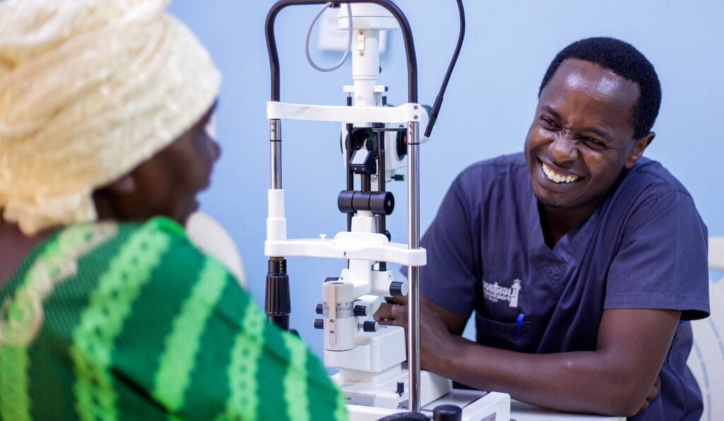 Dr Chege with a patient in hospital in Malawi