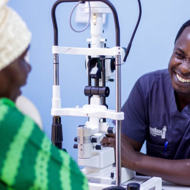 Dr Chege with a patient in hospital in Malawi