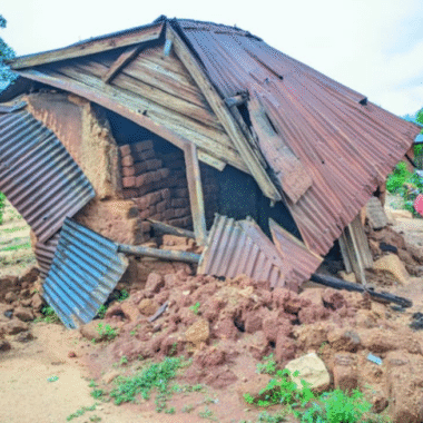 A brick, wood and corrugated iron hut that is falling down and have been severely damaged.