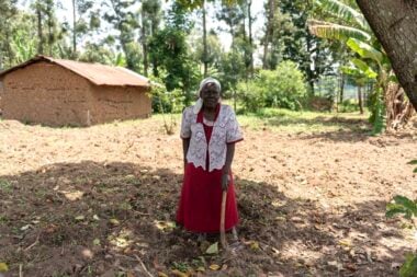 Benedetta, who had cataract surgery to treat her sight loss, standing in her home village in rural Kenya.