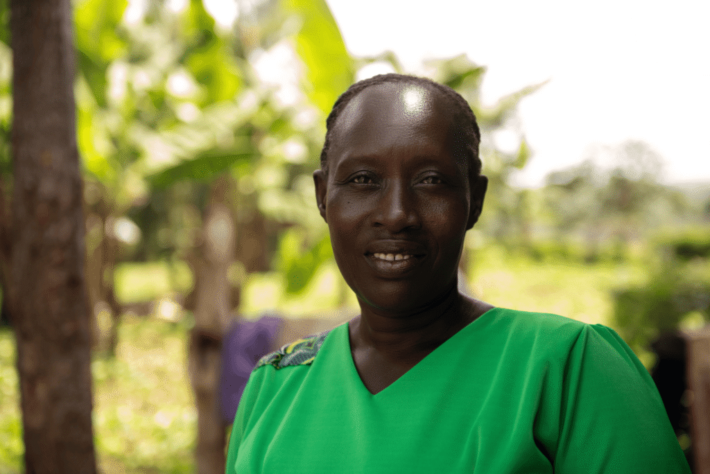 Rodah, wearing green, smiles at the camera.