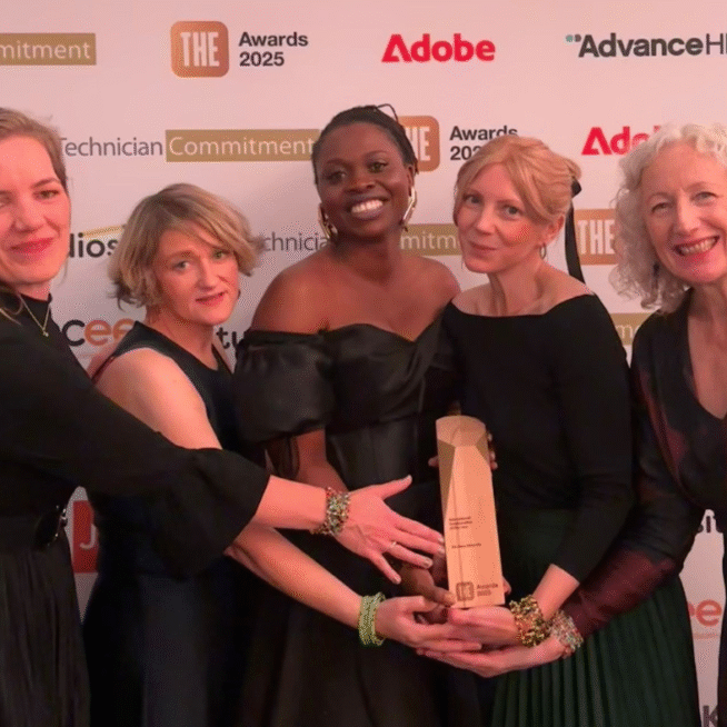 Five people hold the Times Higher Education Award for a girls' inclusive education collaboration. Behind them are the logos of the sponsoring organisations.