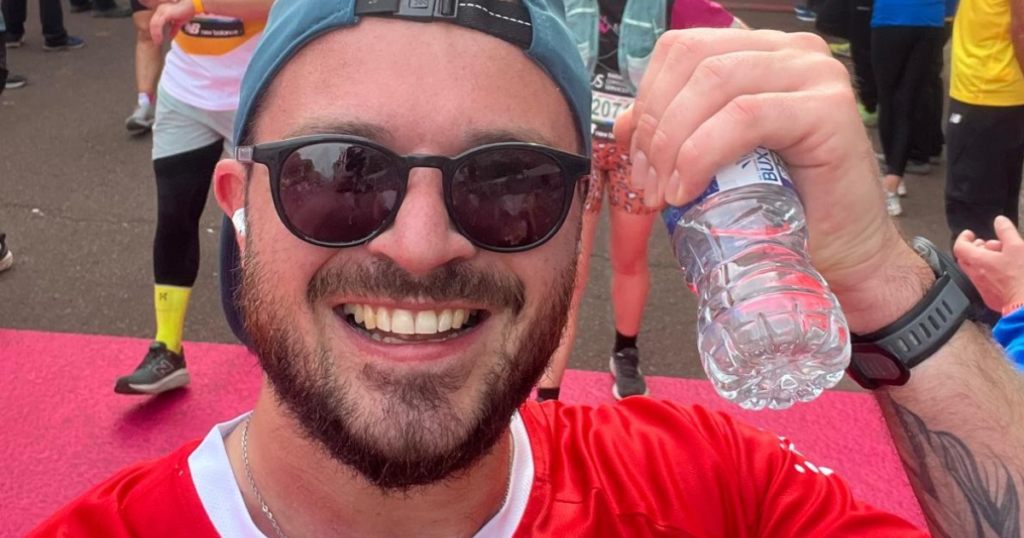 Alex holding his marathon medal