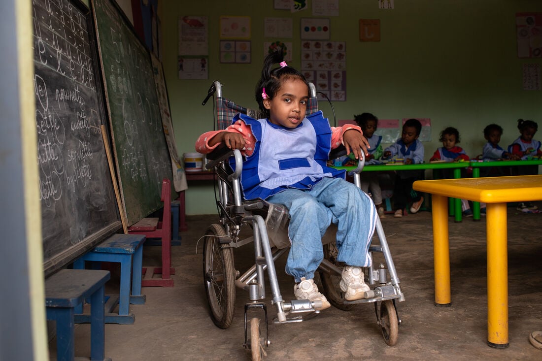 A young girl sitting in a wheelchair at school. She is from Madagascar,