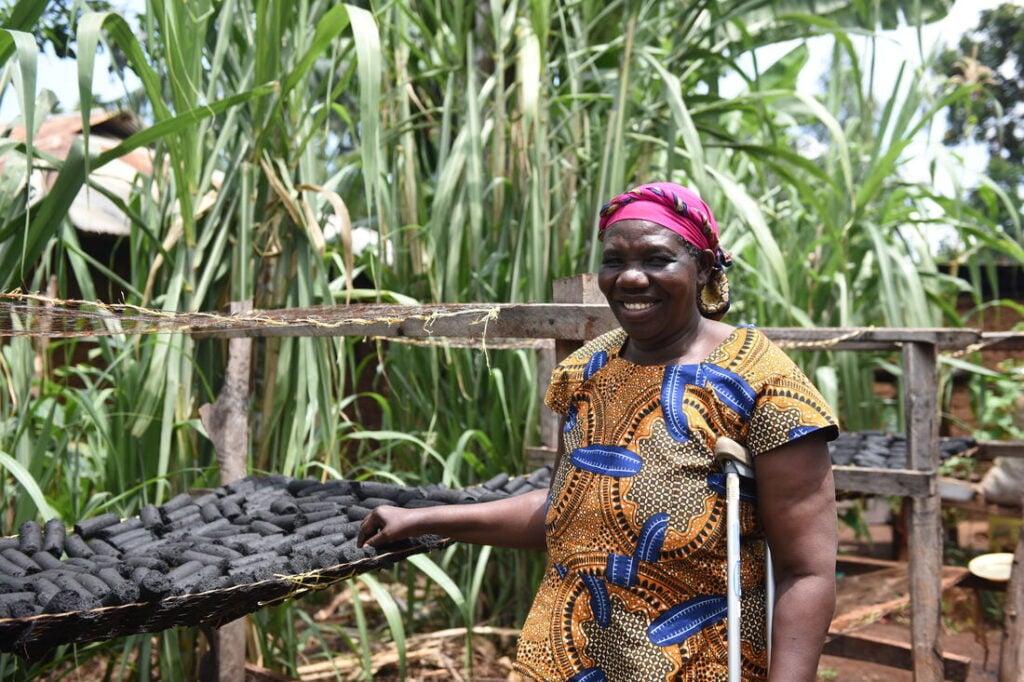 A lady from Kenya standing next to coal.