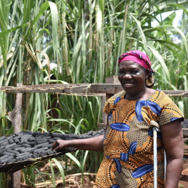 A lady from Kenya standing next to coal.