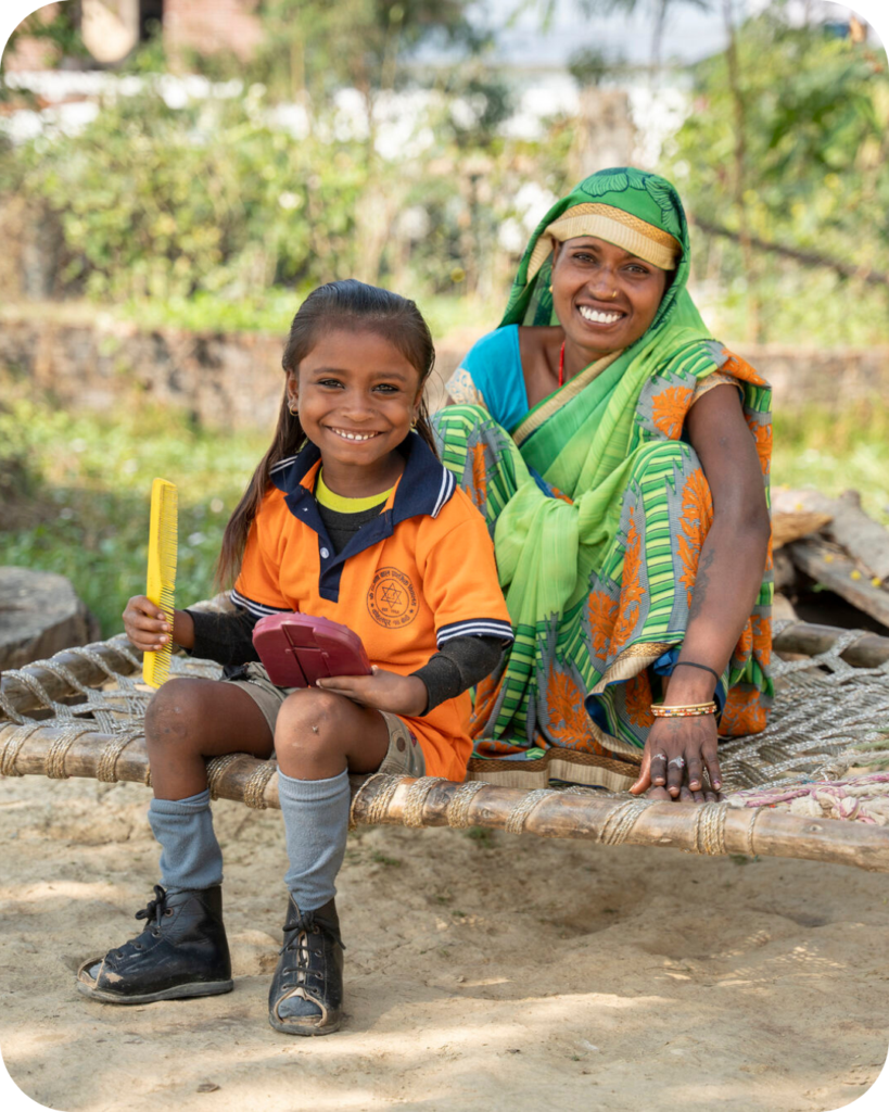 A girl who is wearing leg braces sits with her mum.