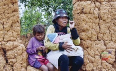 Baby Sombiniaina from Madagascar, held by her mother and at on a wall with her sister. Your love can light the way to save sight and even lives.